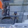 Another craftman guiding the placement of a large stone in place.  Machine and operator and guide working as a team.  Working on the weekend to complete the work on time, that is dedication.  